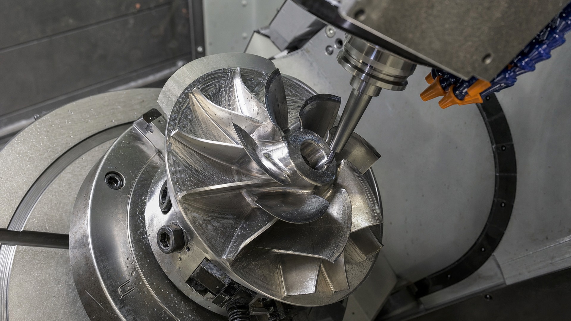 Close-up of five-axis machining on stainless steel pump impeller blades.