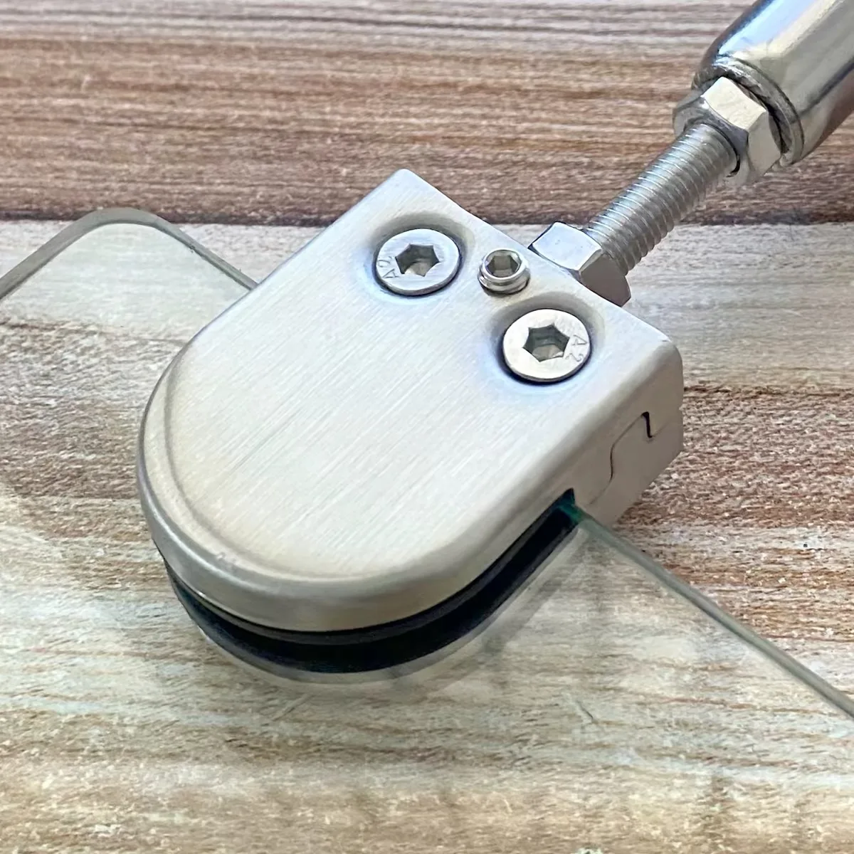 Close view of stainless steel glass clamp with threaded adjustment rod and lock nuts