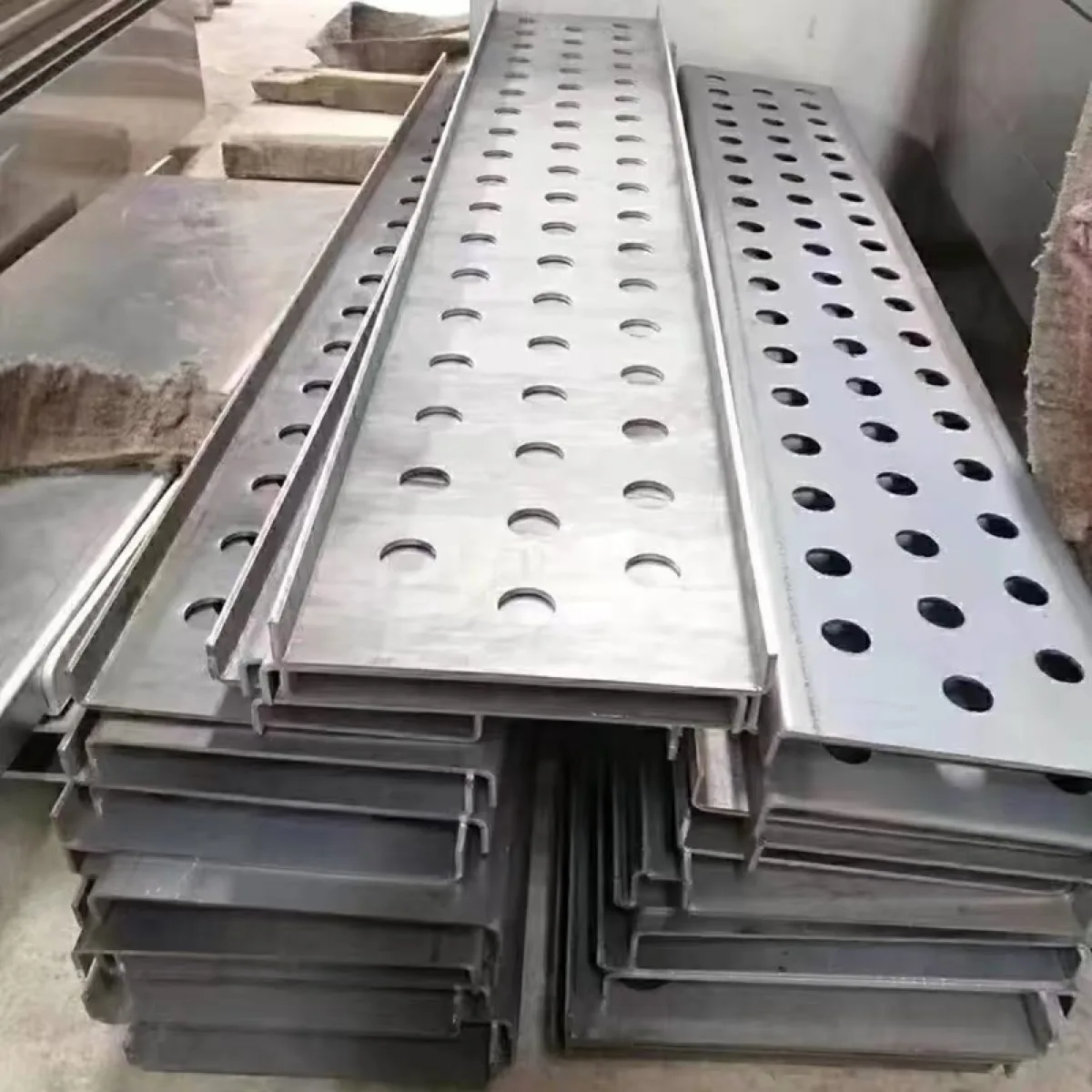 Cut and perforated stainless steel channel sections prepared for fabrication