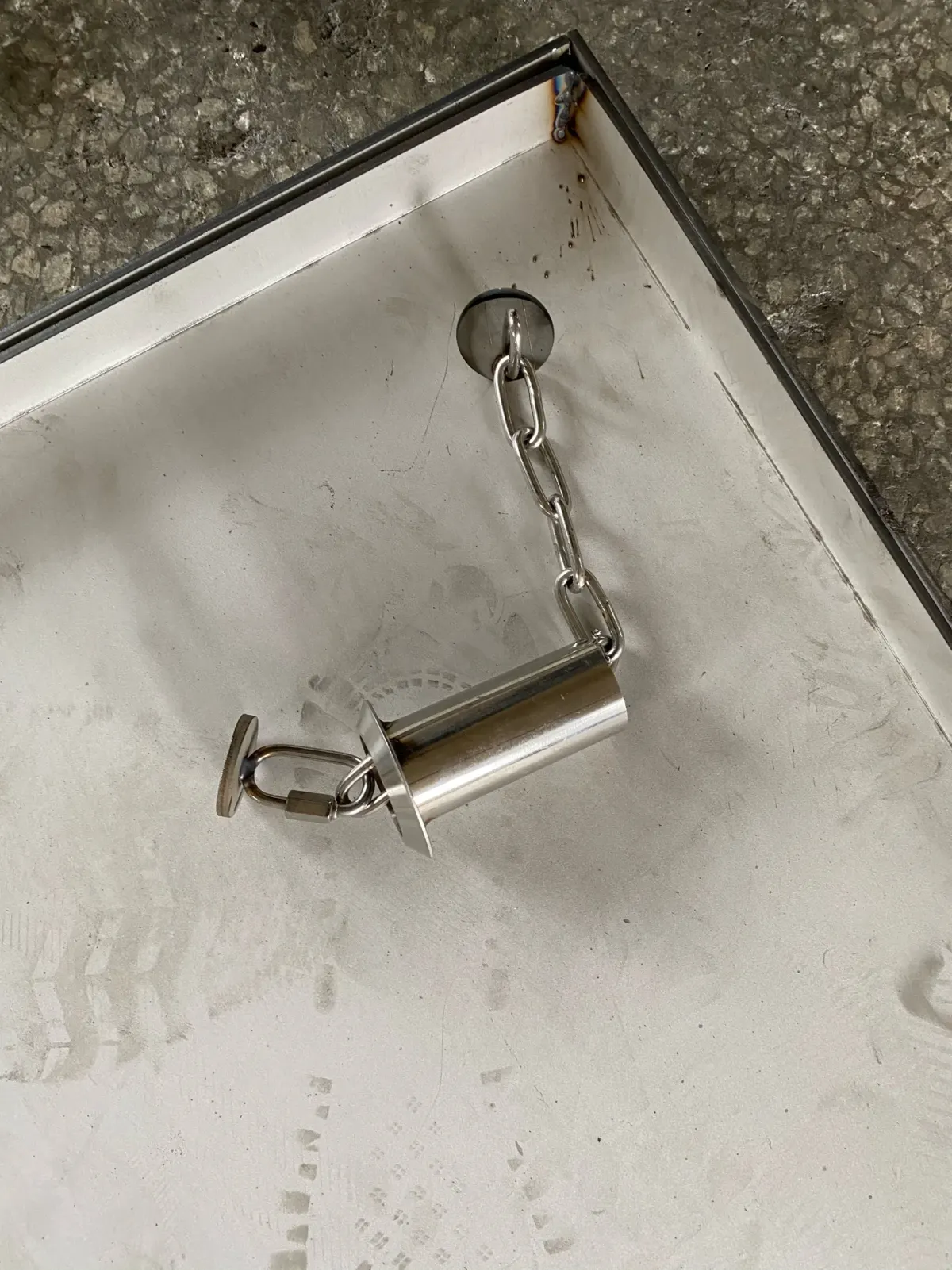 Llave de elevación y cadena de retención de acero inoxidable para tapa de acceso al suelo.