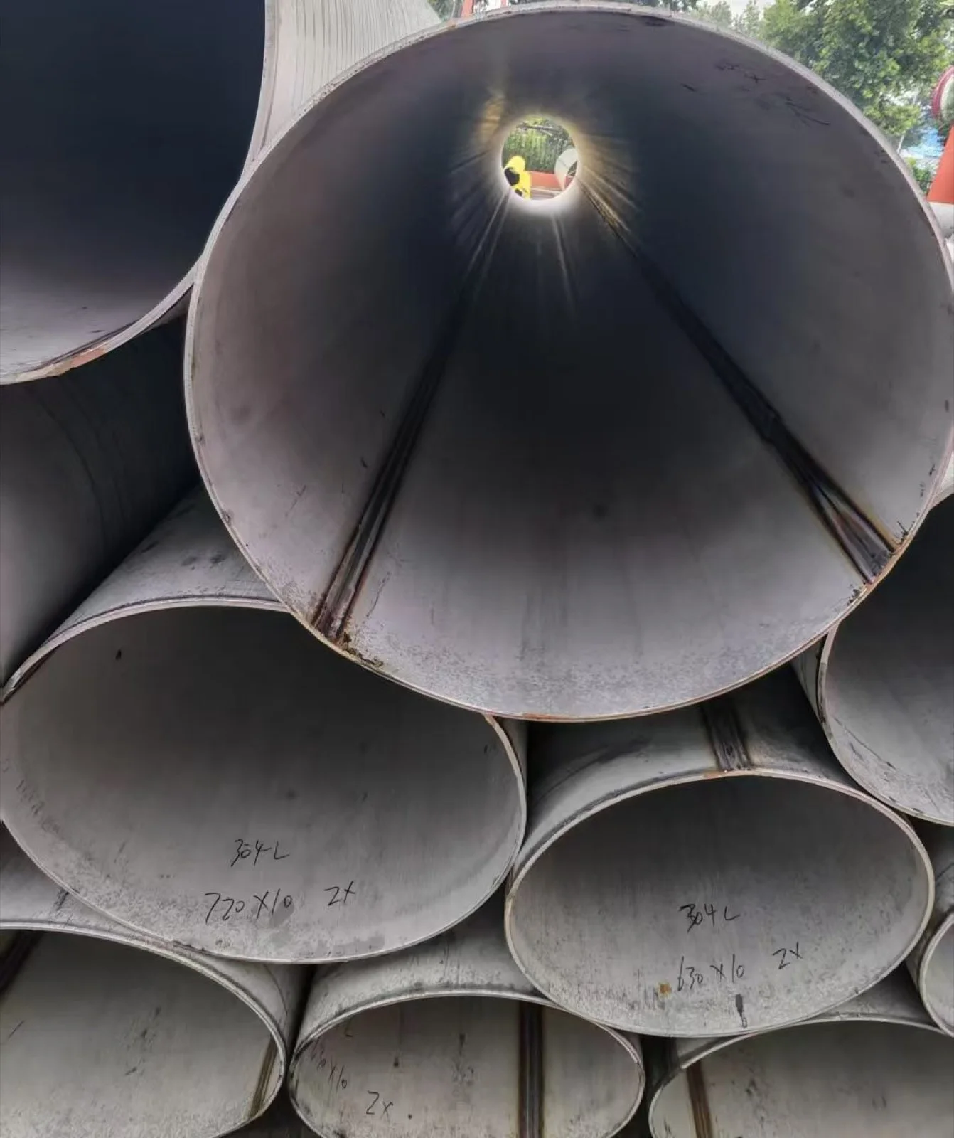 Large circular stainless steel sections showing longitudinal weld seams
