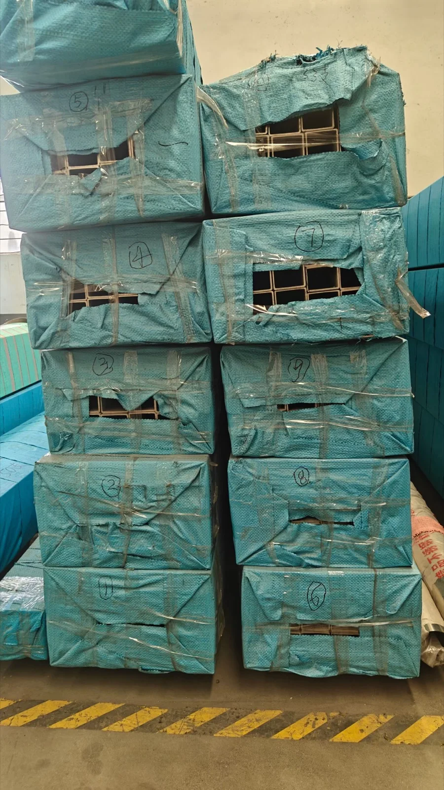 Wrapped bundles of stainless steel square tubes stacked for handling