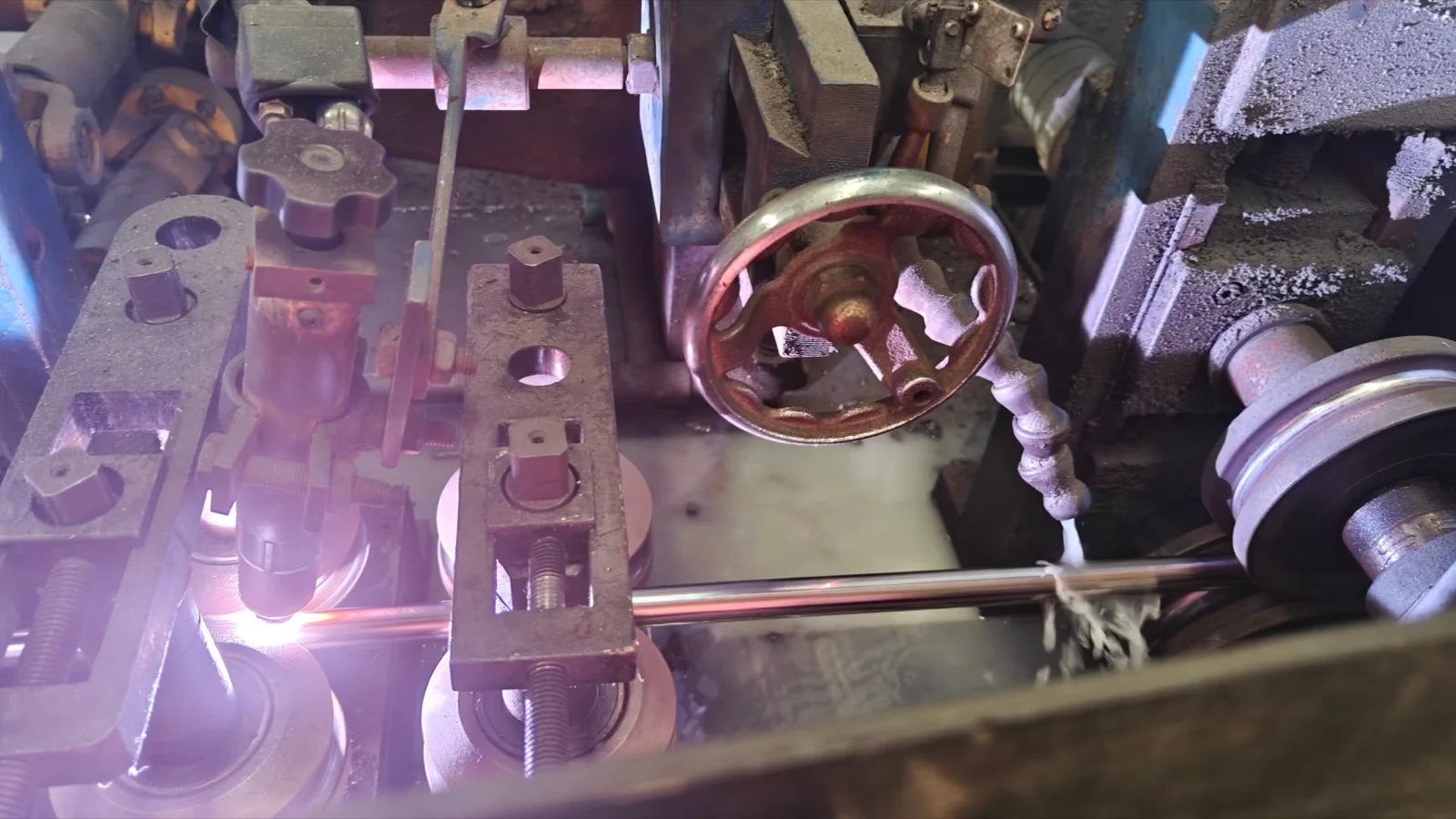 Close-up of the tube welding station with an active welding arc